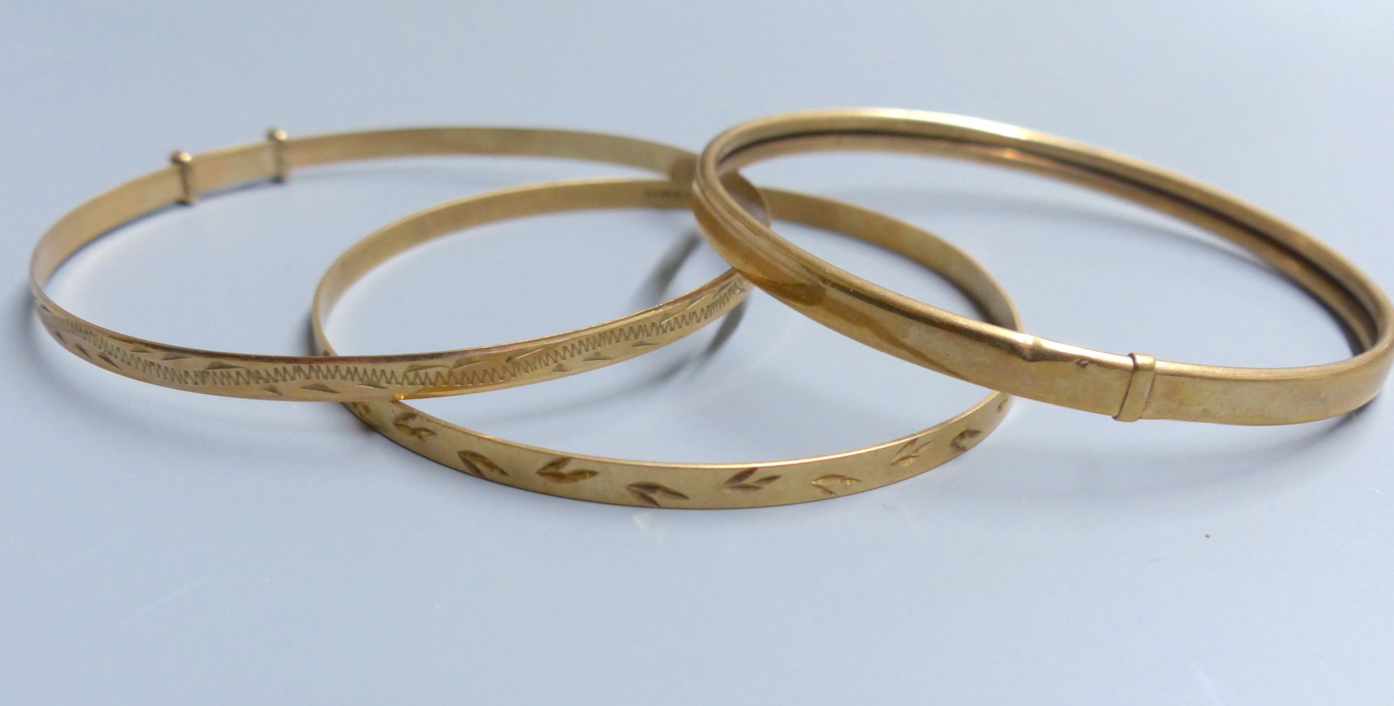 Three modern 9ct gold bangles,